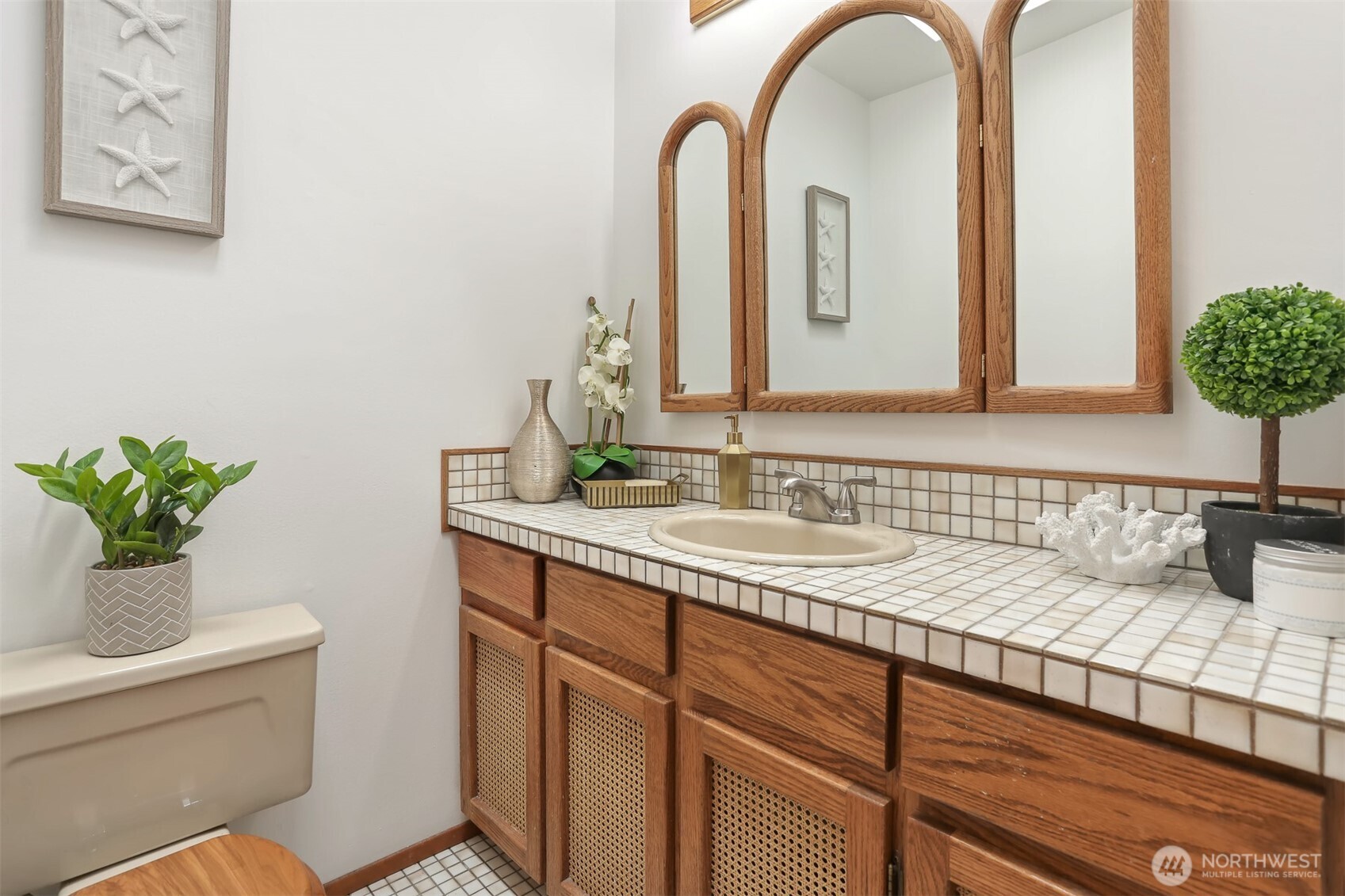 Half bathroom with tile flooring and countertops.
