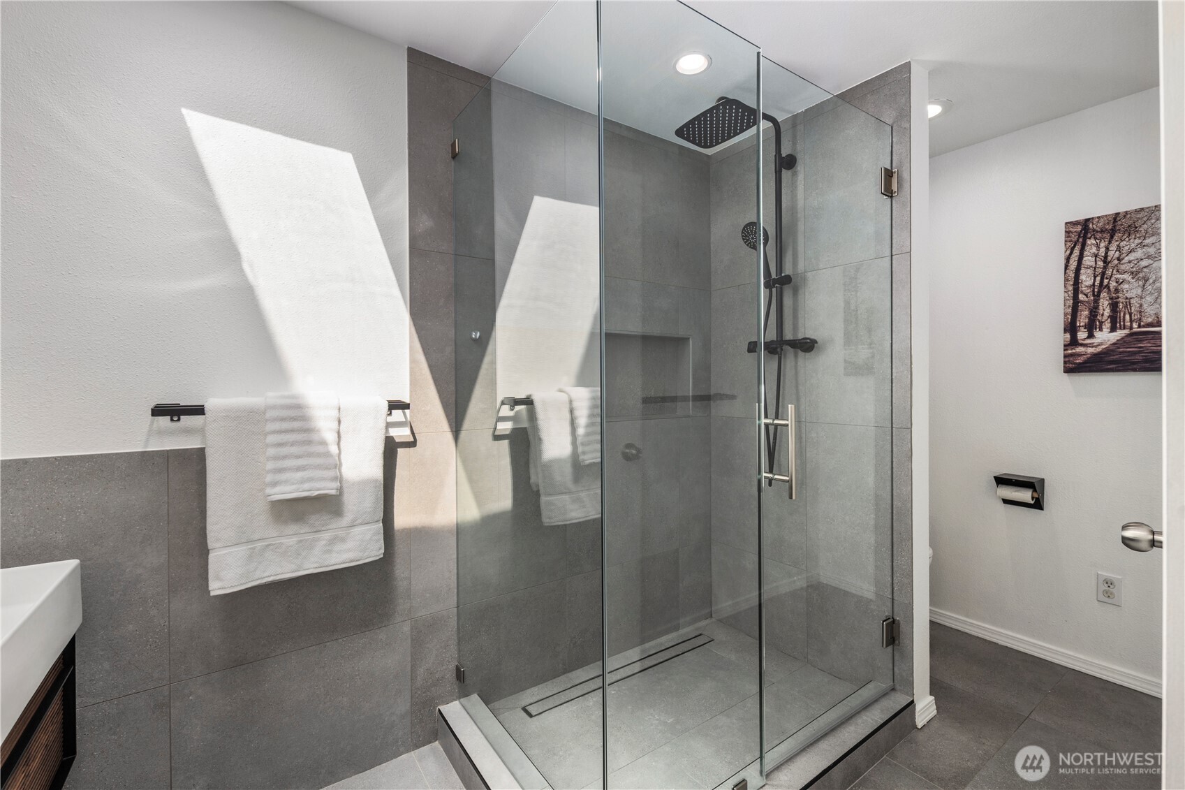 Frameless glass shower and water closet in primary suite.
