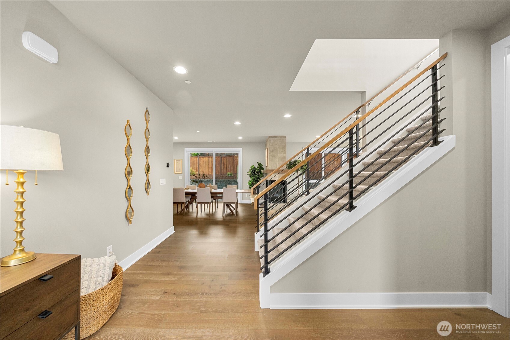 Hardwoods throughout main level of the home lead you to the open railing staircase