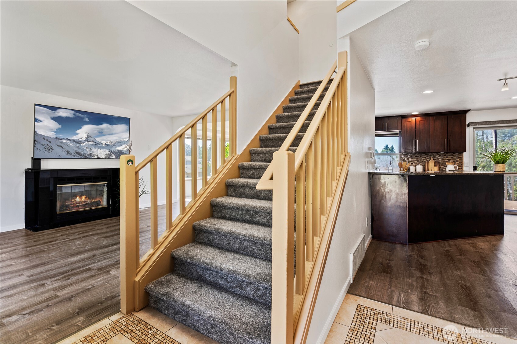 The extra wide staircase with new carpeting leads upstairs to the primary suite, additional bedrooms and full bathroom.