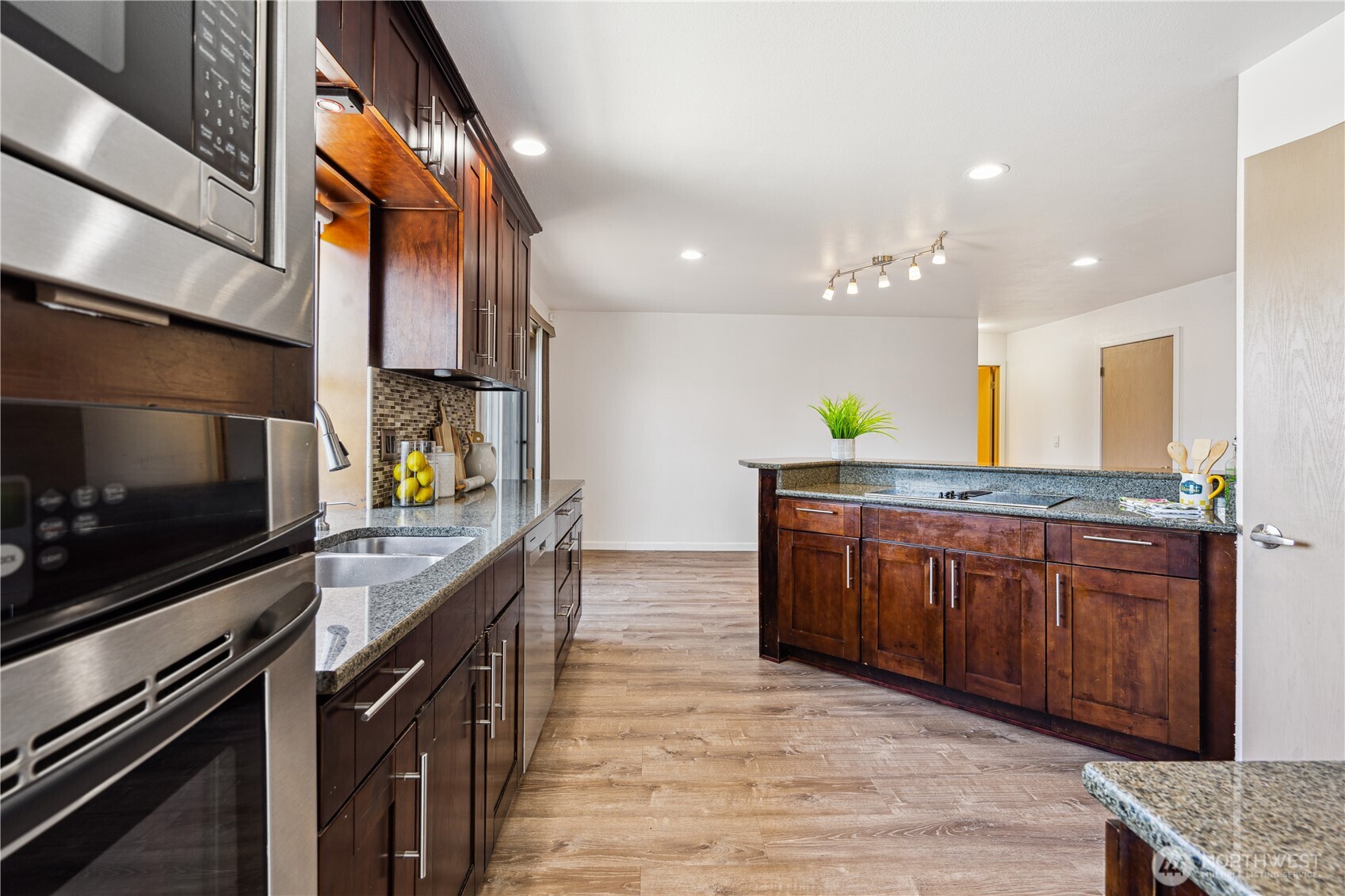 A large garden window and recessed lighting illuminates this bright open kitchen. Easily serve meals from cooktop to the table in the breakfast nook.