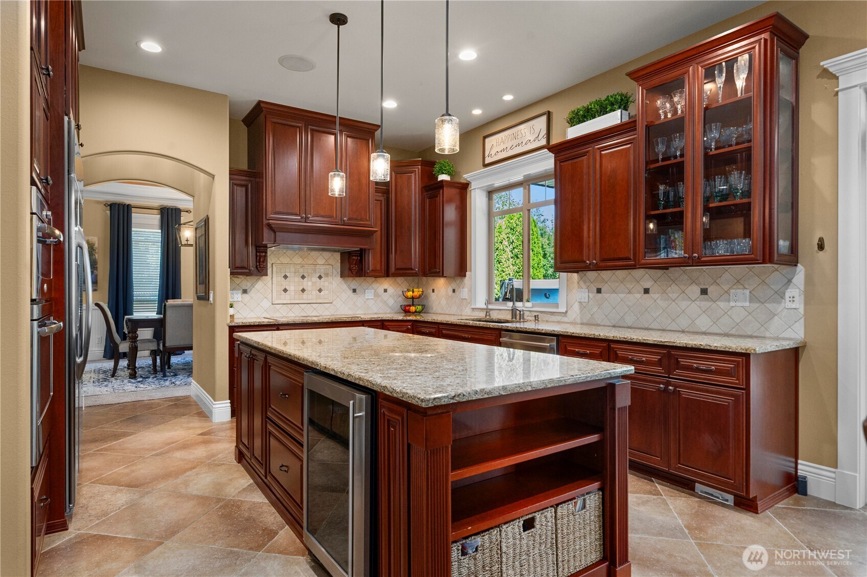 Island w/mini beverage fridge, tile backsplash, undermount & in-cabinet lighting.