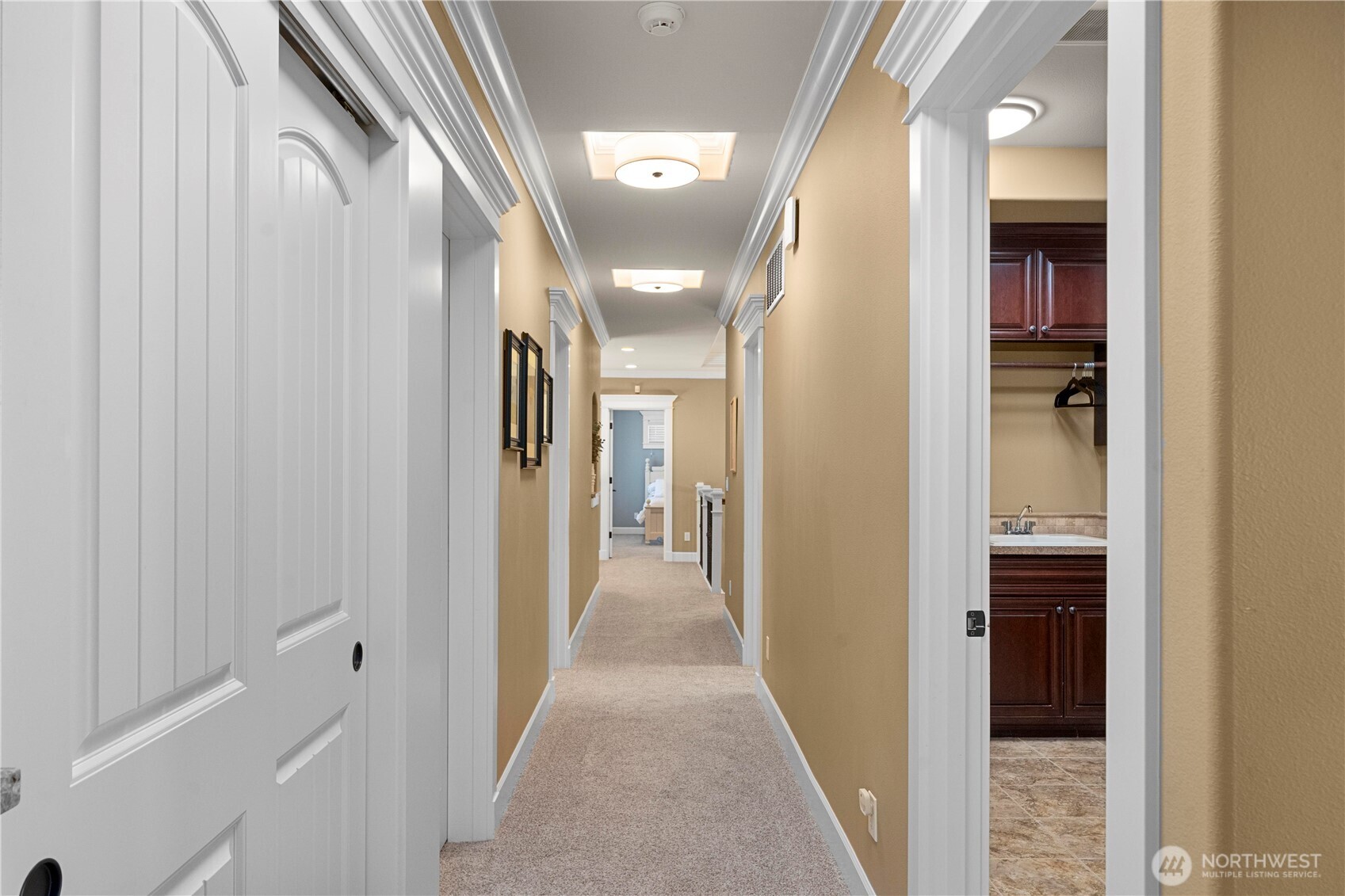 Hallway leading to other bedrooms, bathrooms, bonus room & theater room. Utility room on right.