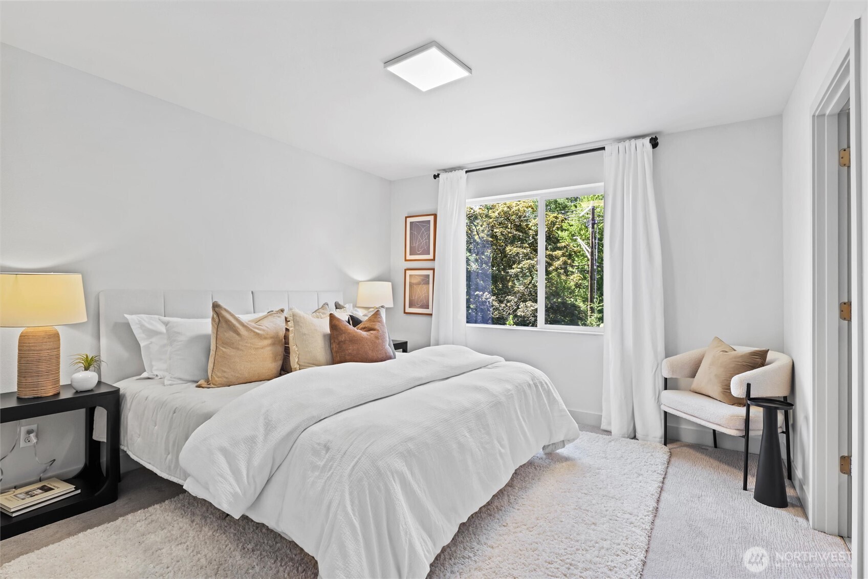 Spacious primary bedroom easily fits a king size bed and looks over peaceful greenbelt.