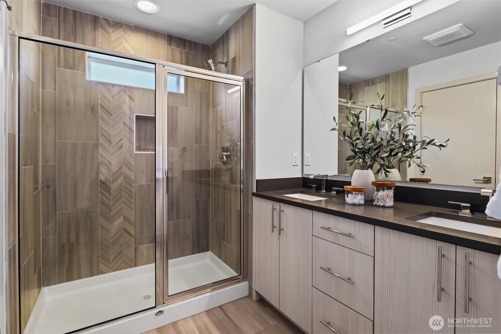 Primary bath boasts oversized shower plus dual vanities with quartz counters and undermount sinks