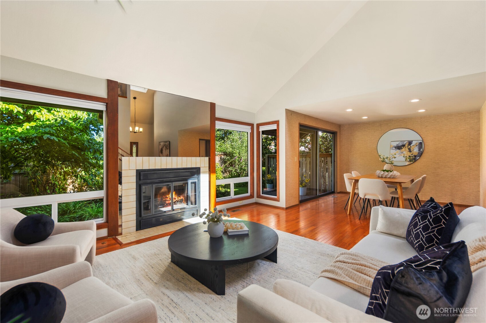 The living room boasts vaulted ceilings, a gas fireplace, and large windows bringing in lots of natural light throughout the day