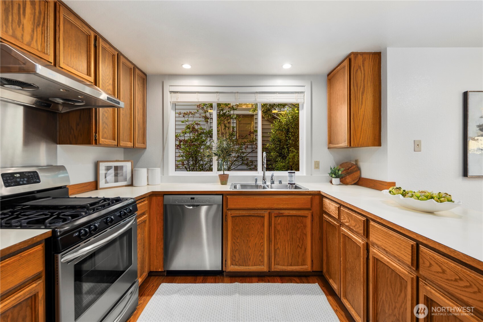 Stainless steel appliances, a gas stove, and hardwood floors make this kitchen the perfect set up for any home chef
