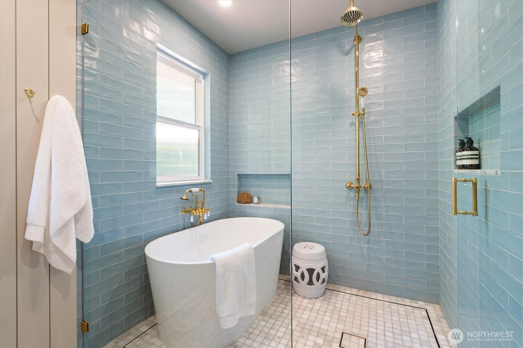 Primary en suite bathroom features stylized wet room with soaking tub and high-end plumbing fixtures.