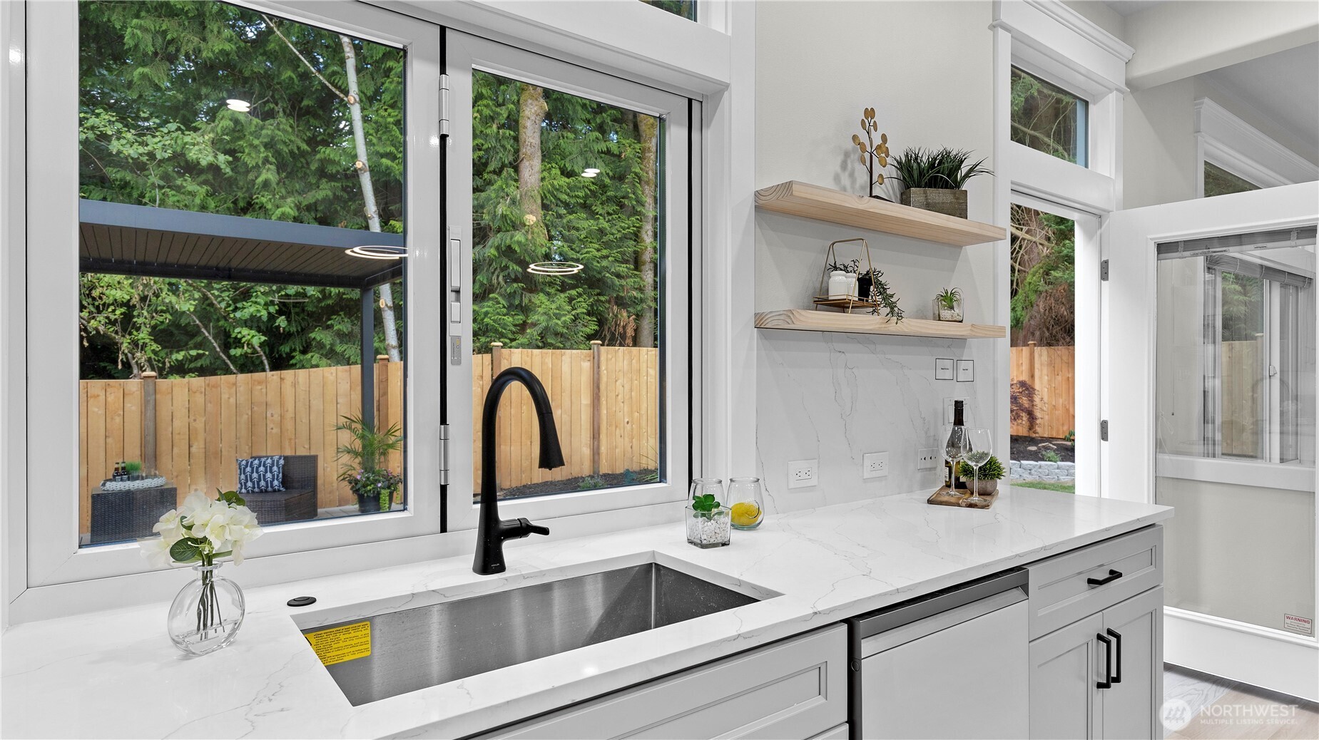 Quartz counter extends under accordion door to bar on outdoor deck