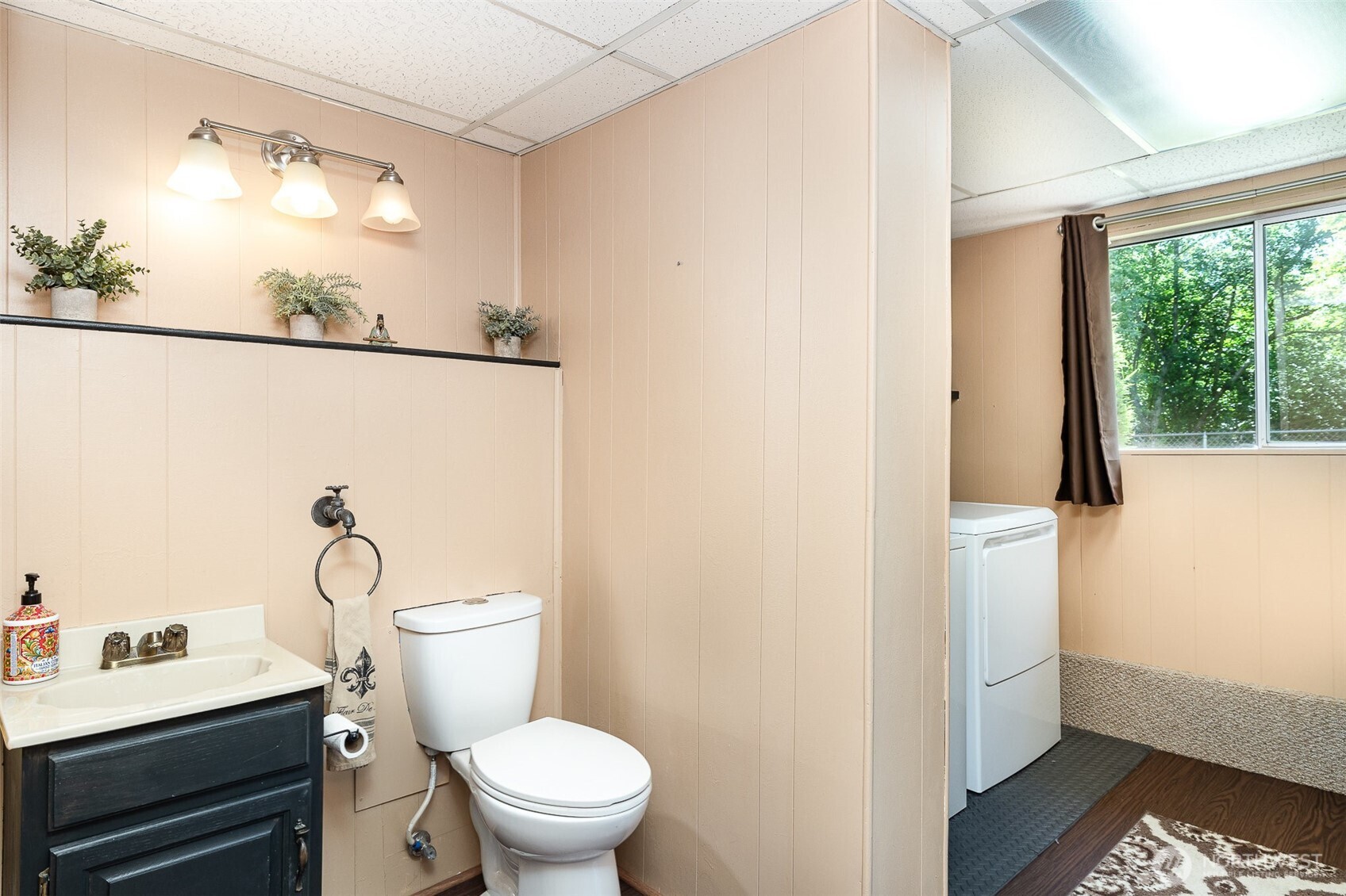 Convenient 1/2 bathroom connected to the laundry area, with washer and dryer included for your ease.