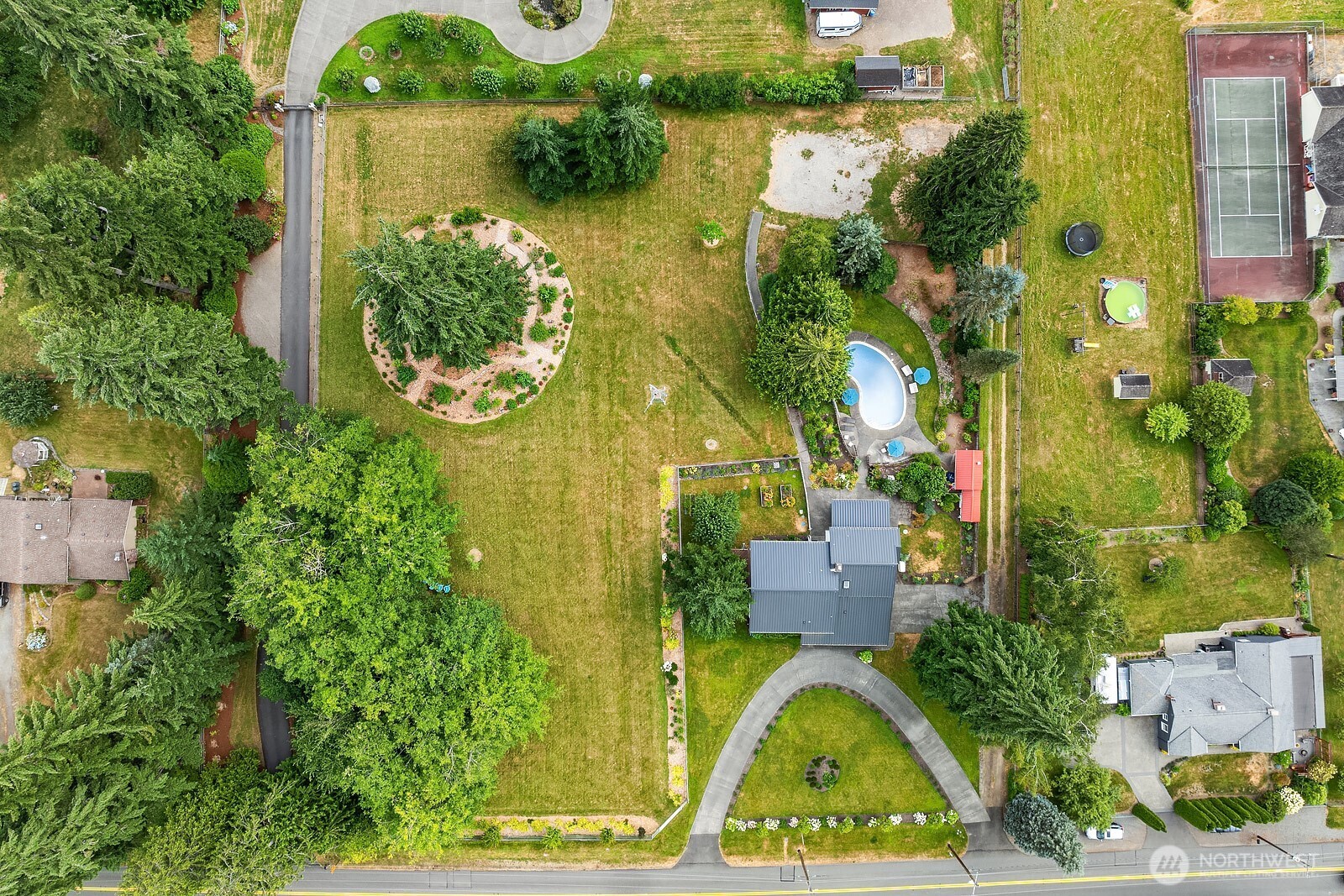 This picture shows the actual full acreage and house sitting on this open aired, garden filled 2 acre lot. On the SW corner of lot is where an ADU or structure can be built. Rightside driveway is owned by this house but back has easement to get access to their property.
