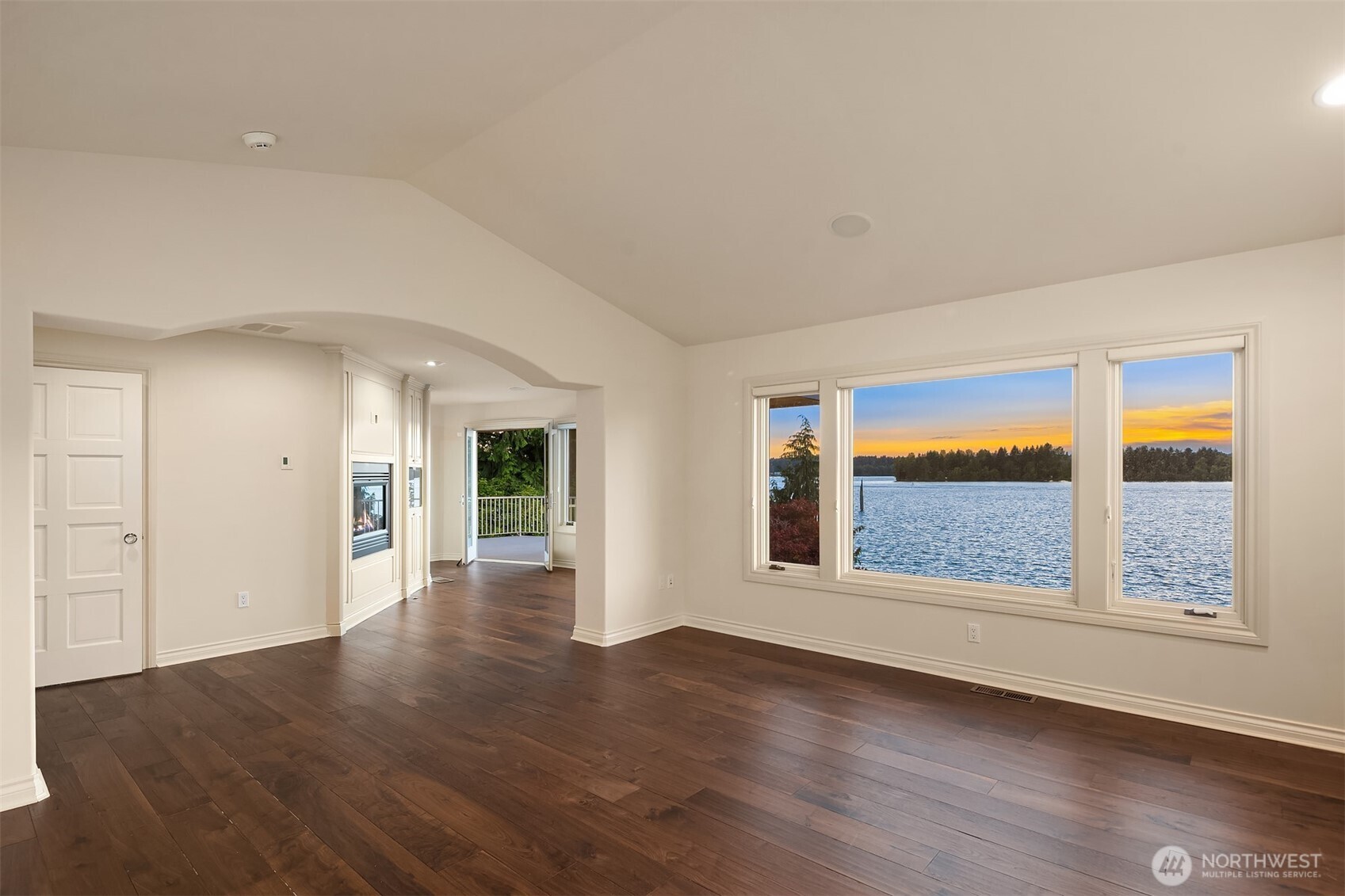 The grand staircase leads to the Large Primary Suite w/vaulted ceilings. Picturesque Lake Tapps views.