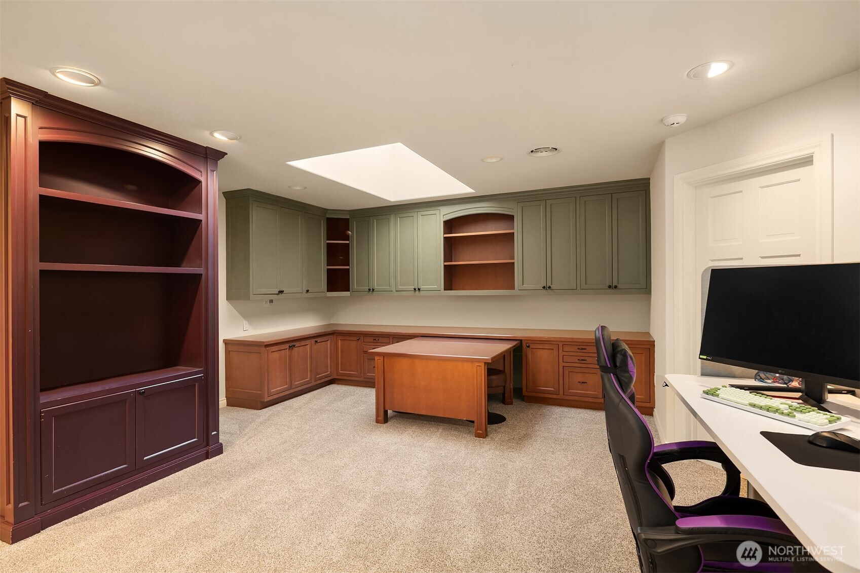 Large loft space with built in desks, bookcase, pull out desk, skylight and spacious adjacent storage closet.