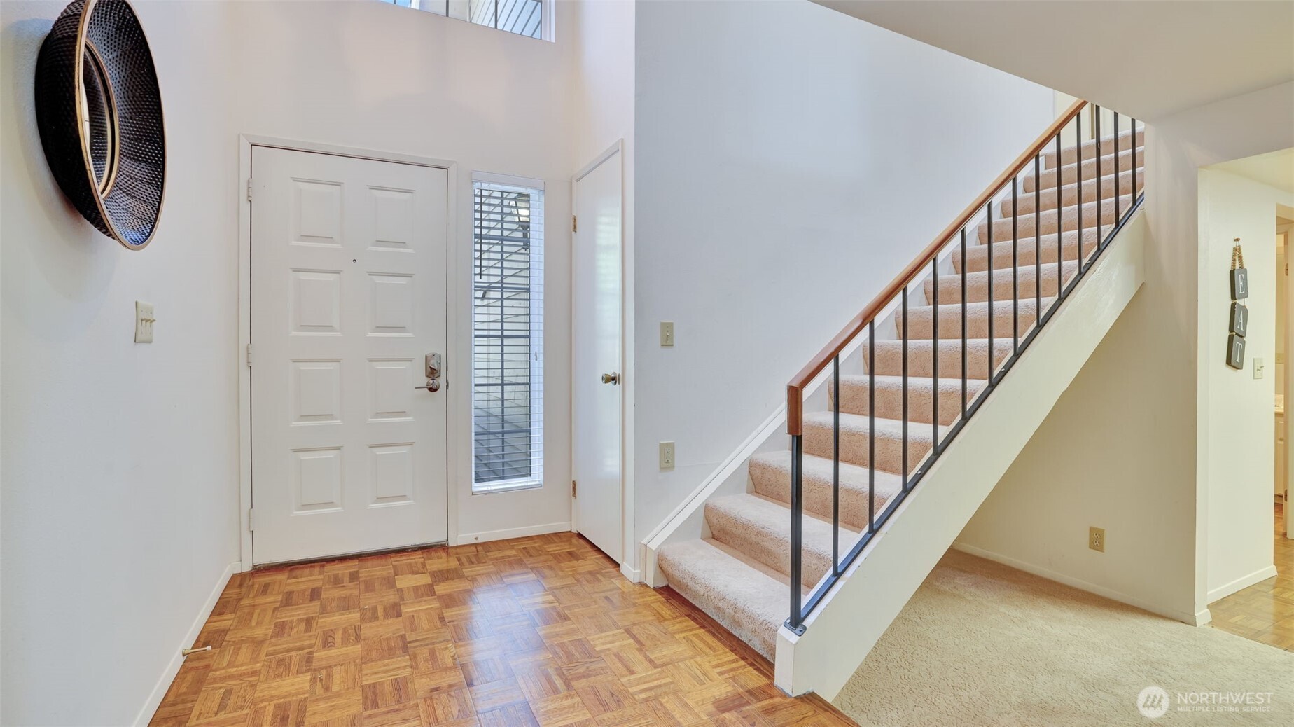 Step onto gleaming hardwood floors as you enter, with immediate access to the upstairs, a wide entryway, and soaring ceilings that create an open and fresh feeling