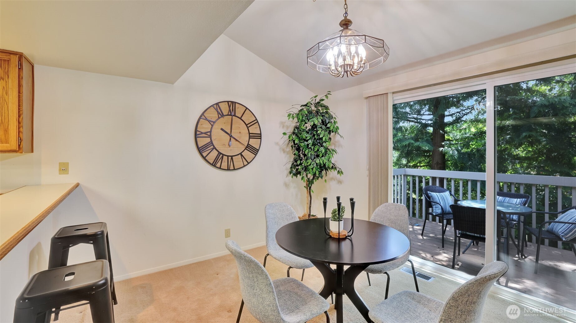 A grand sliding glass door and vaulted ceilings create a sophisticated, light-filled dining space with timeless design