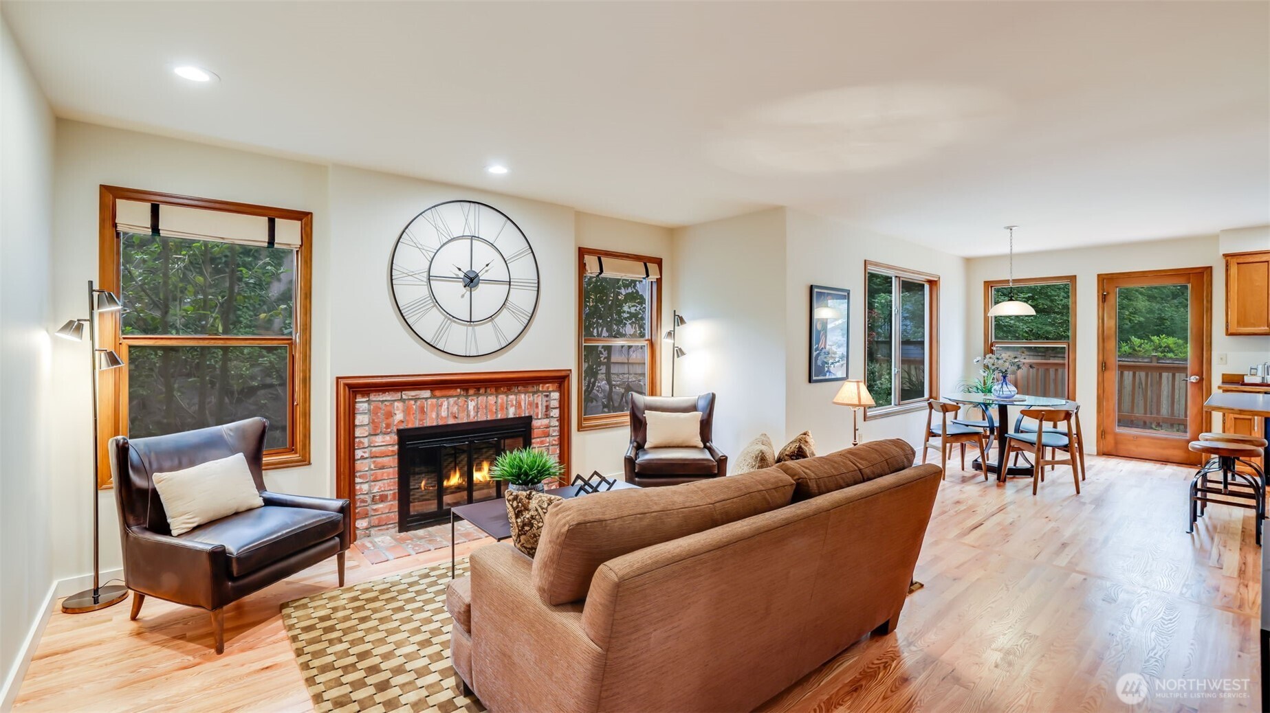 The warm and cozy family room has new hardwood floors and a warm fireplace with a brick surround.