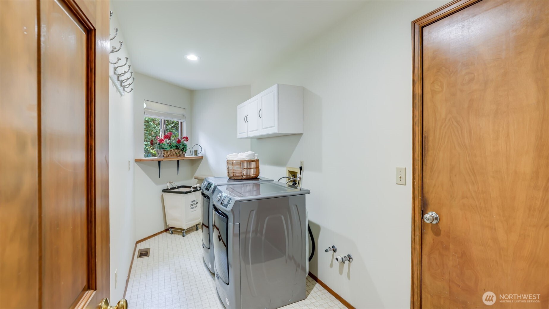 The utility room with the washer and dryer remaining. Cabinets, vinyl floor, and pre-plumbed for a deep sink.