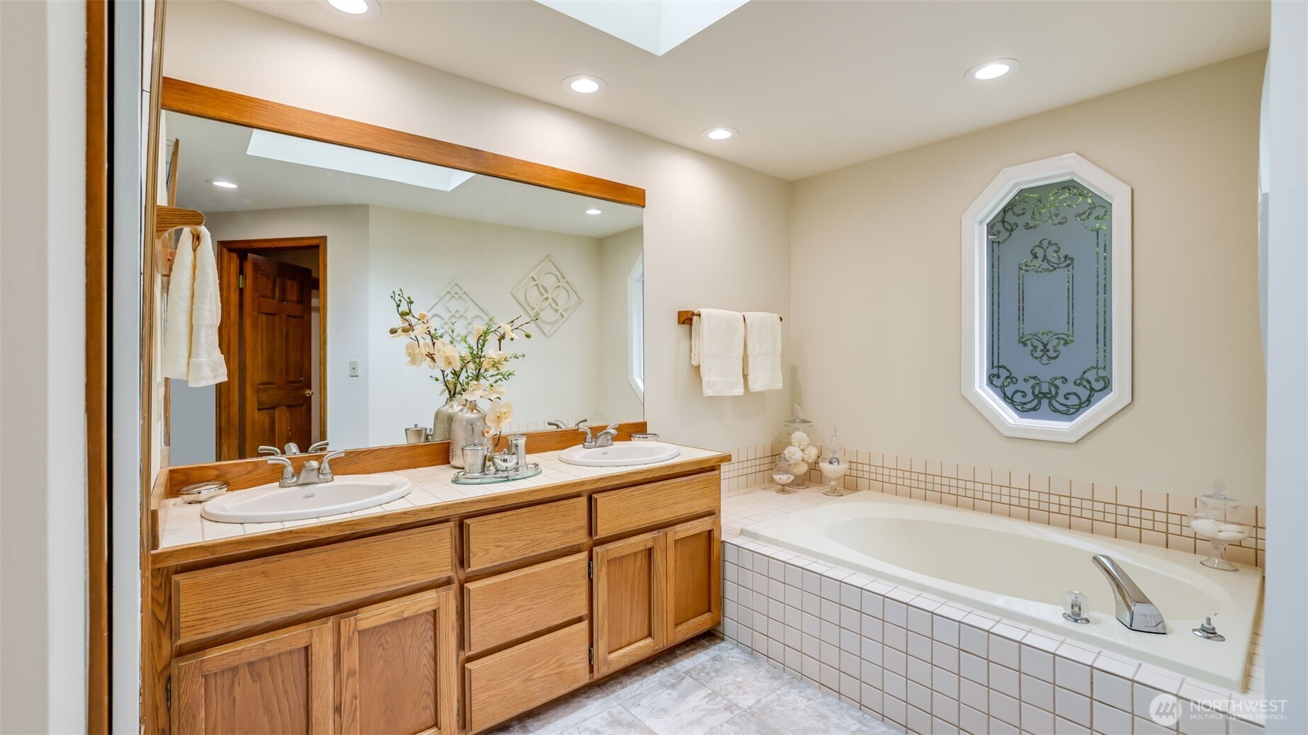 The primary bath has 2 sinks, new vinyl, soak tub, shower and a large skylight.
