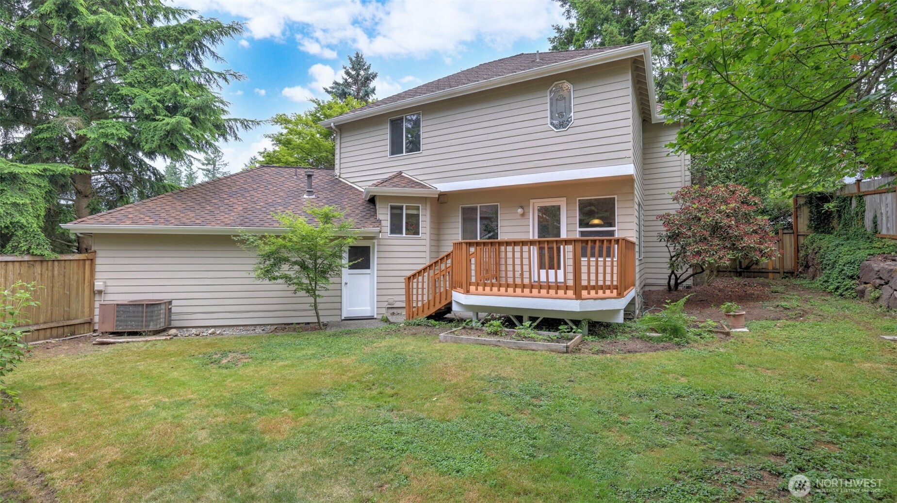 The fully fenced backyard has a gate, a side door to the garage and a new deck.