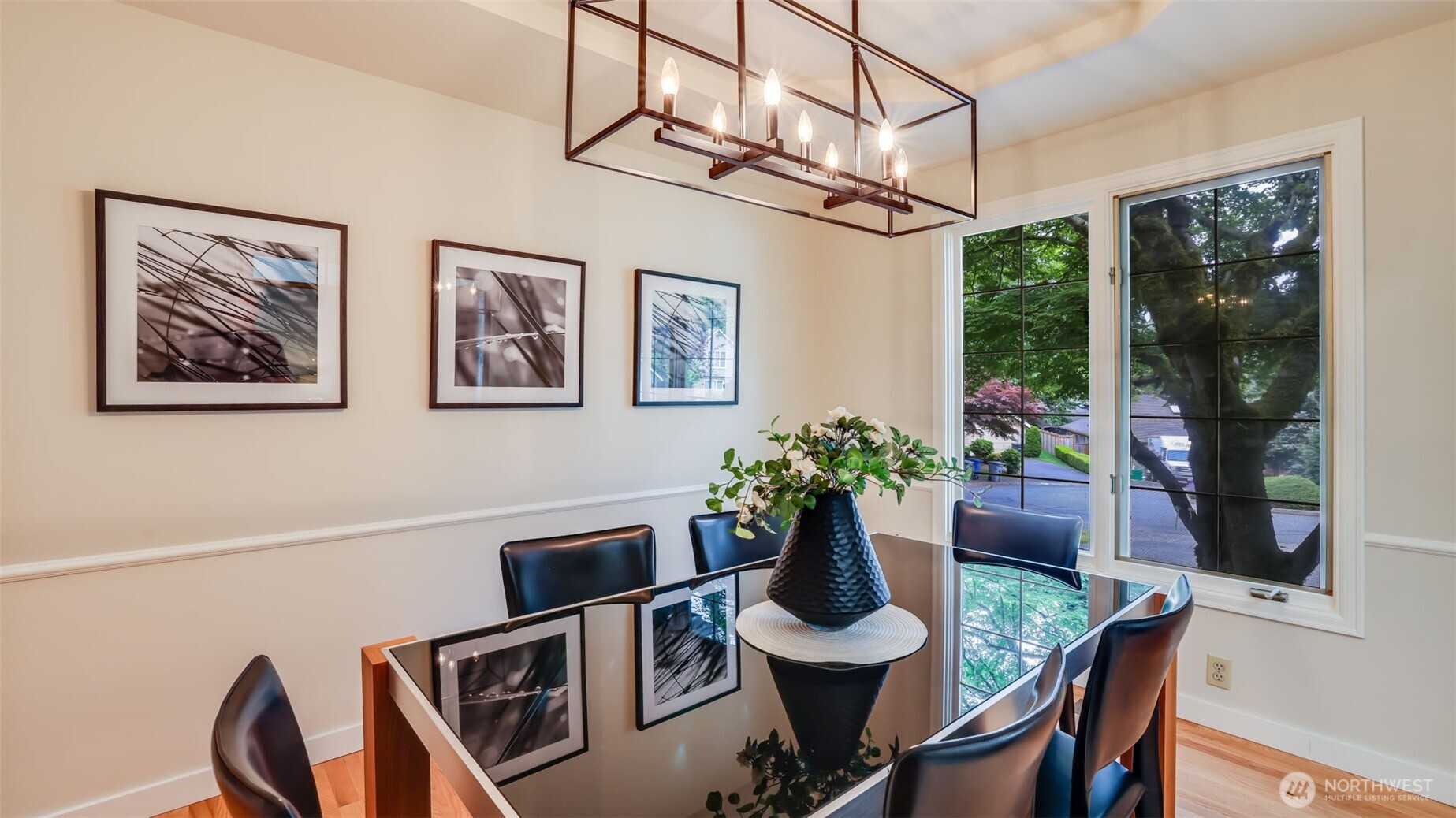 A 2nd view of the dining room with a large window showing off the mature landscaping.