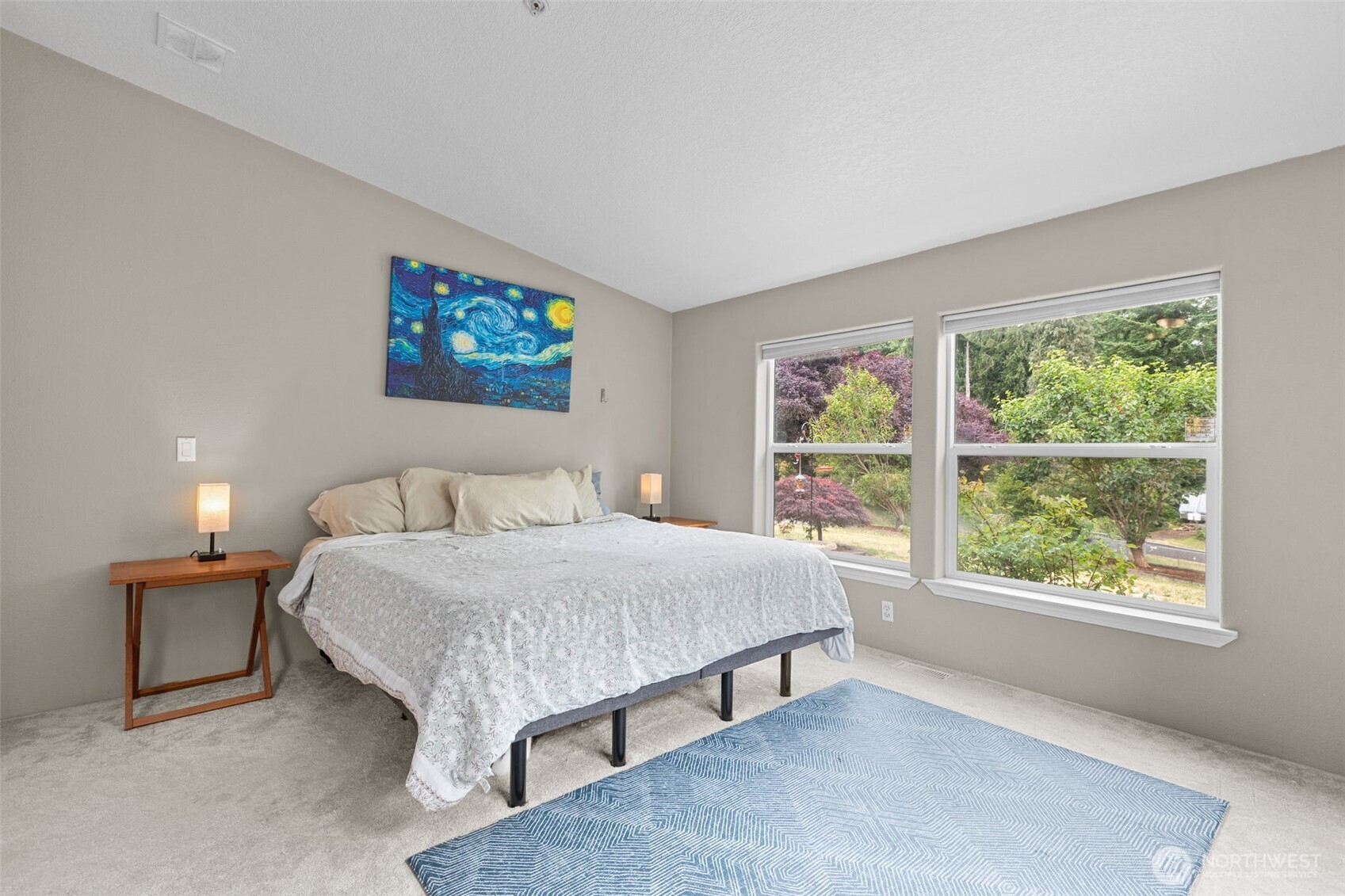 PrimaryComfort meets character in this light-filled bedroom. A large picture window brings in soft light, while neutral tones and plush carpeting provide a calm and cozy atmosphere. Ideal for rest, work, or creative pursuits—with room for a keyboard or reading nook. Bedroom 1