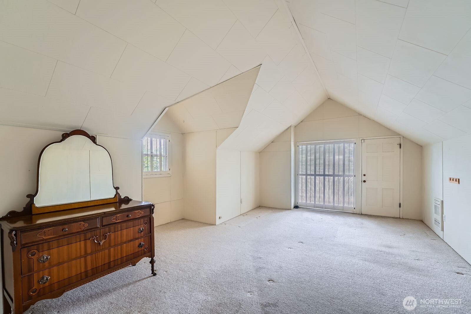 Upper level primary bedroom with vaulted ceilings & private balcony.
