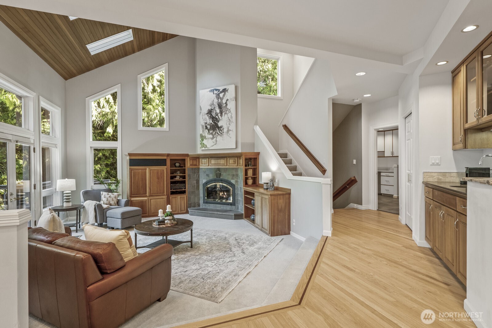The gathering room boasts a tall vaulted cedar lined ceiling with skylights and cherry built ins.