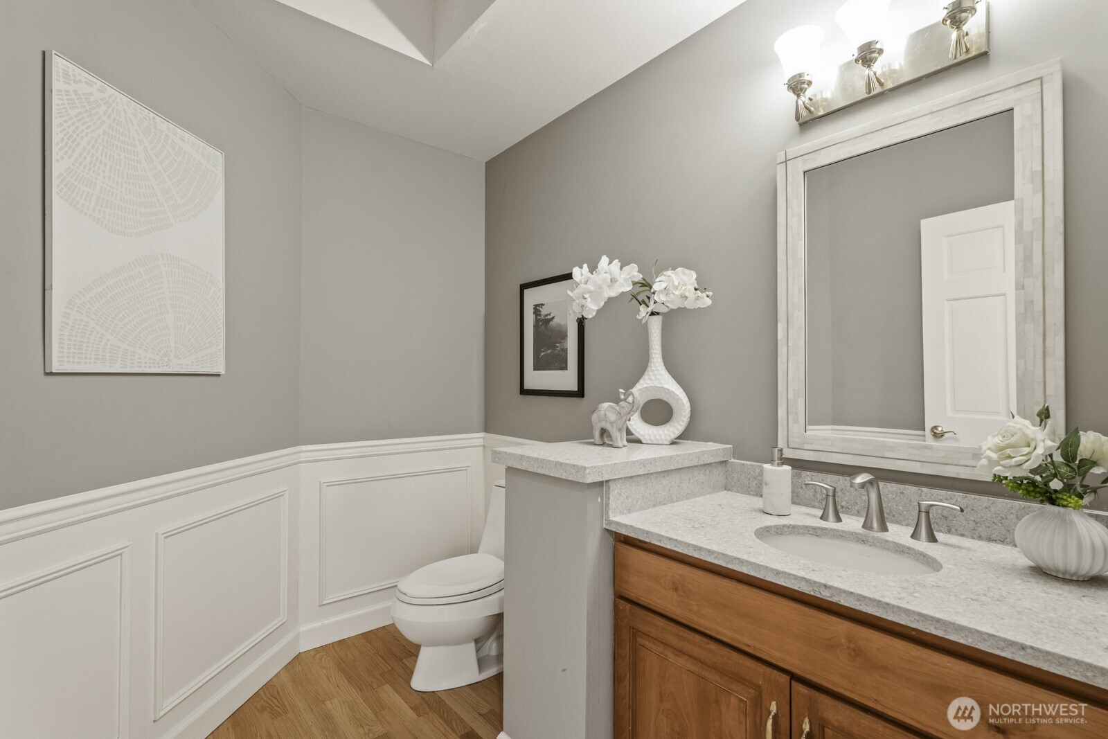 The guest powder room with quartz vanity is conveniently located off this hallway.
