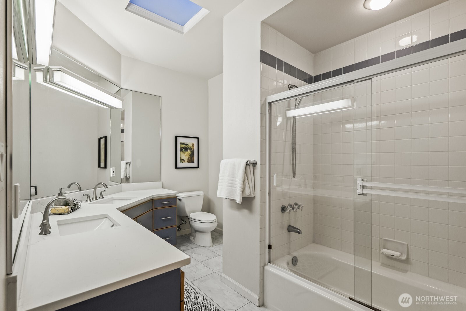 Upstairs hall bathroom with tiled floors and quartz vanity.