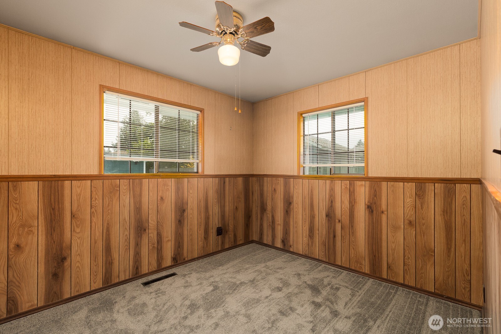 Third bedroom with some really cool, retro style wainscoting and wall paper. Features the ceiling fan and new carpeting and paint.