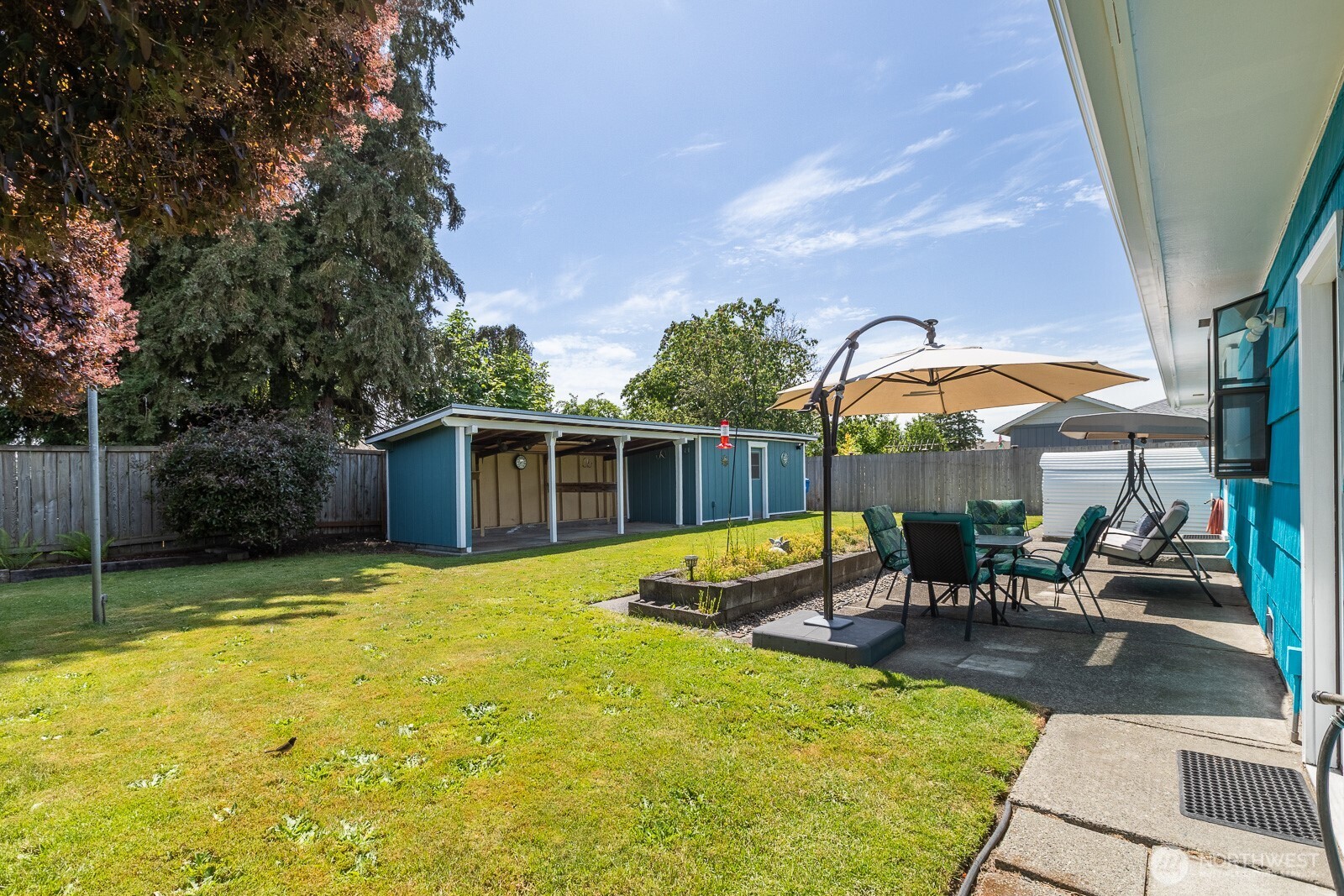 Featuring a lovely back yard with a patio and planter box. The owners are leaving the patio furniture for the lucky buyer!