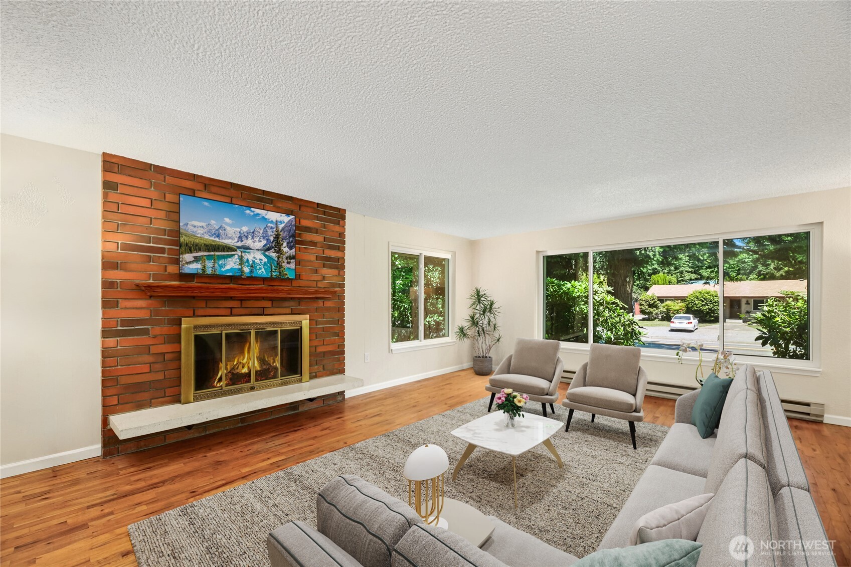 Large Living room features hardwood floors, wood burning fireplace and huge windows.