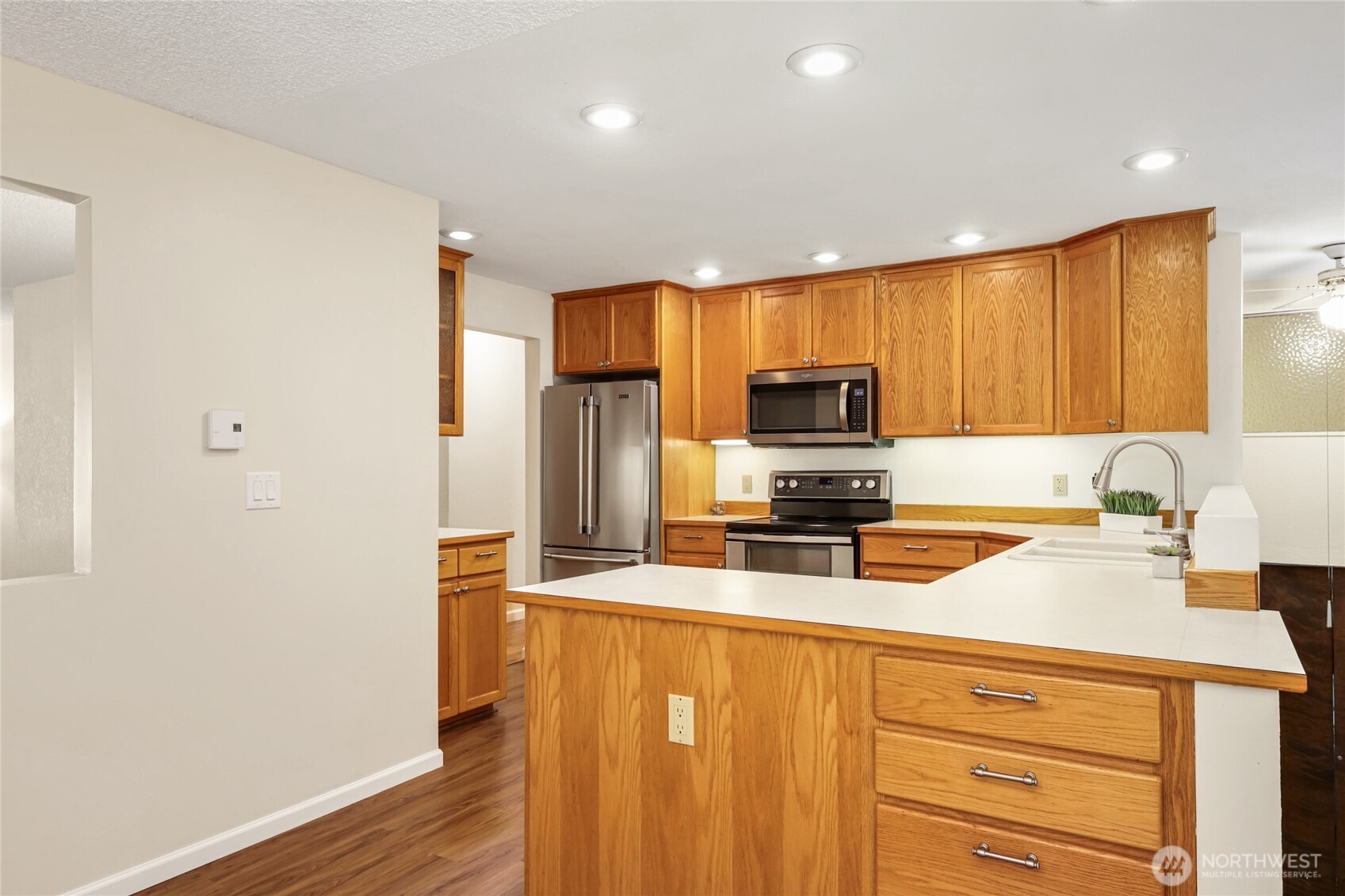 The kitchen has stainless steel appliances, LVP, and plenty of storage. There's even a little panty off to the side of the kitchen. The upper cabinets have under cabinet lights for ambience.