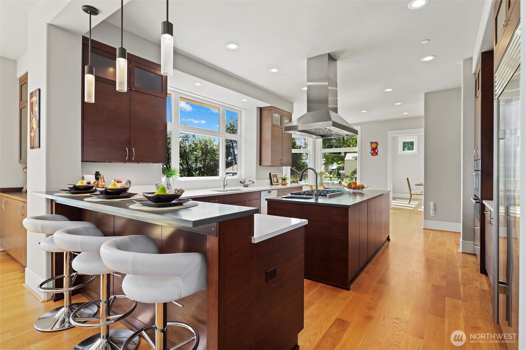 Large chef’s island kitchen with breakfast bar is equipped with top-tier Wolf, Miele, and SubZero appliances & walk-in pantry