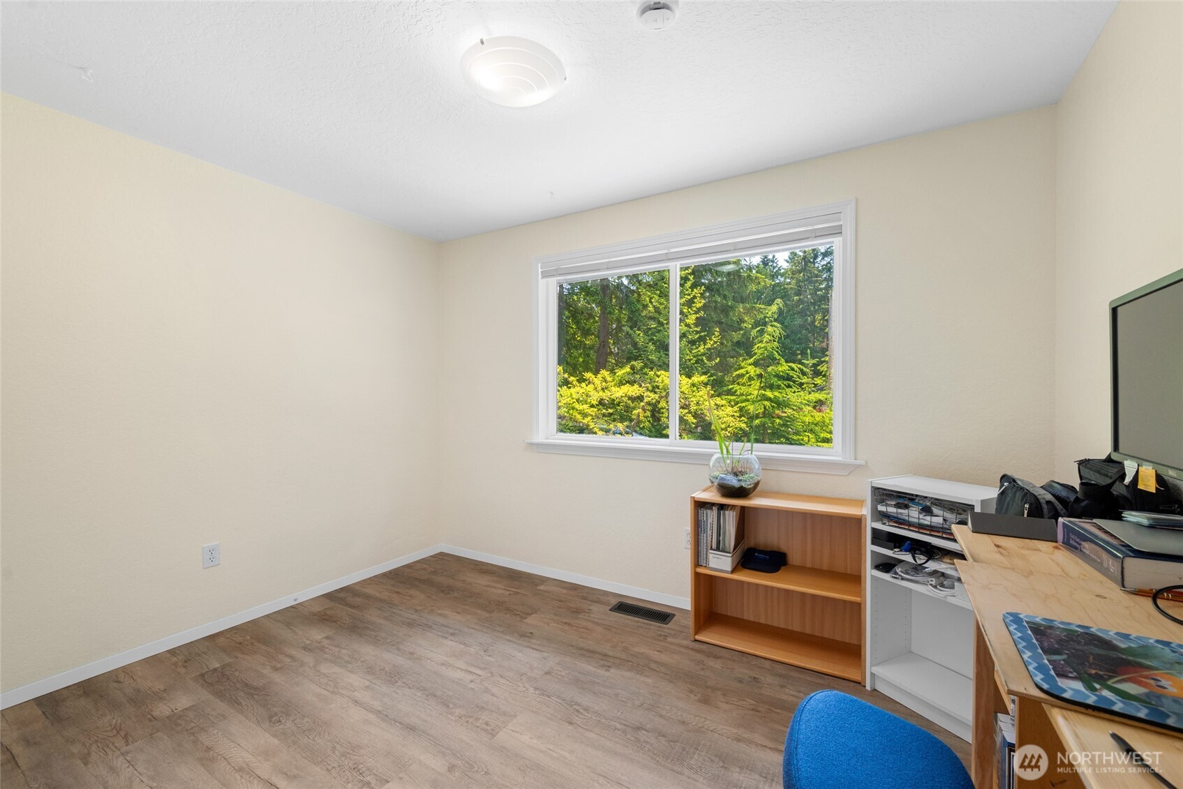 Currently styled as a home office, this second bedroom offers quiet comfort and a large window with leafy views. Perfect for working from home or accommodating guests