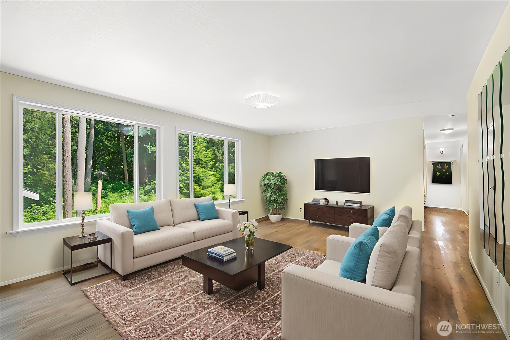 Virtual staging shows the possibilities of this bright, spacious living area Imagine entertaining in this light-filled space with serene greenbelt views. The layout easily accommodates multiple seating zones while staying open to the rest of the main floor.