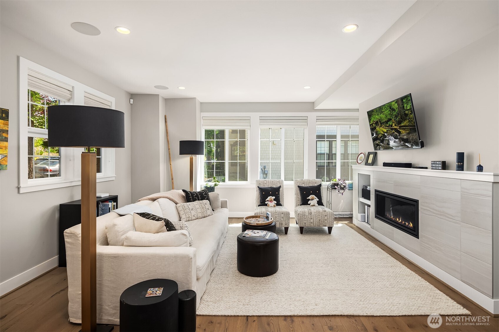 Step inside to a sun-drenched living room featuring rich hardwood floors and a warm, gas fireplace — the perfect space to relax or entertain.