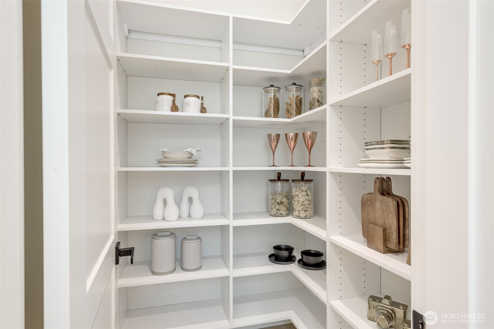 Walk-In Pantry with ample built-in shelving provides extensive storage for all your kitchen essentials.