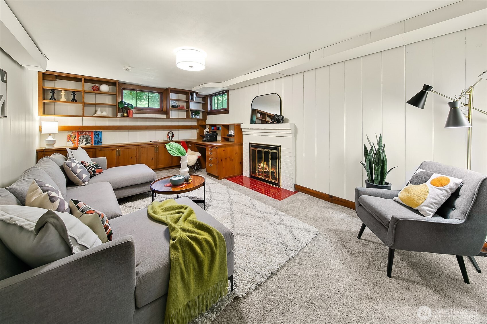 Spacious basement family room (approx. 20'×13') anchored by a fireplace and custom built-ins—ideal for movie nights, games or quiet relaxation.