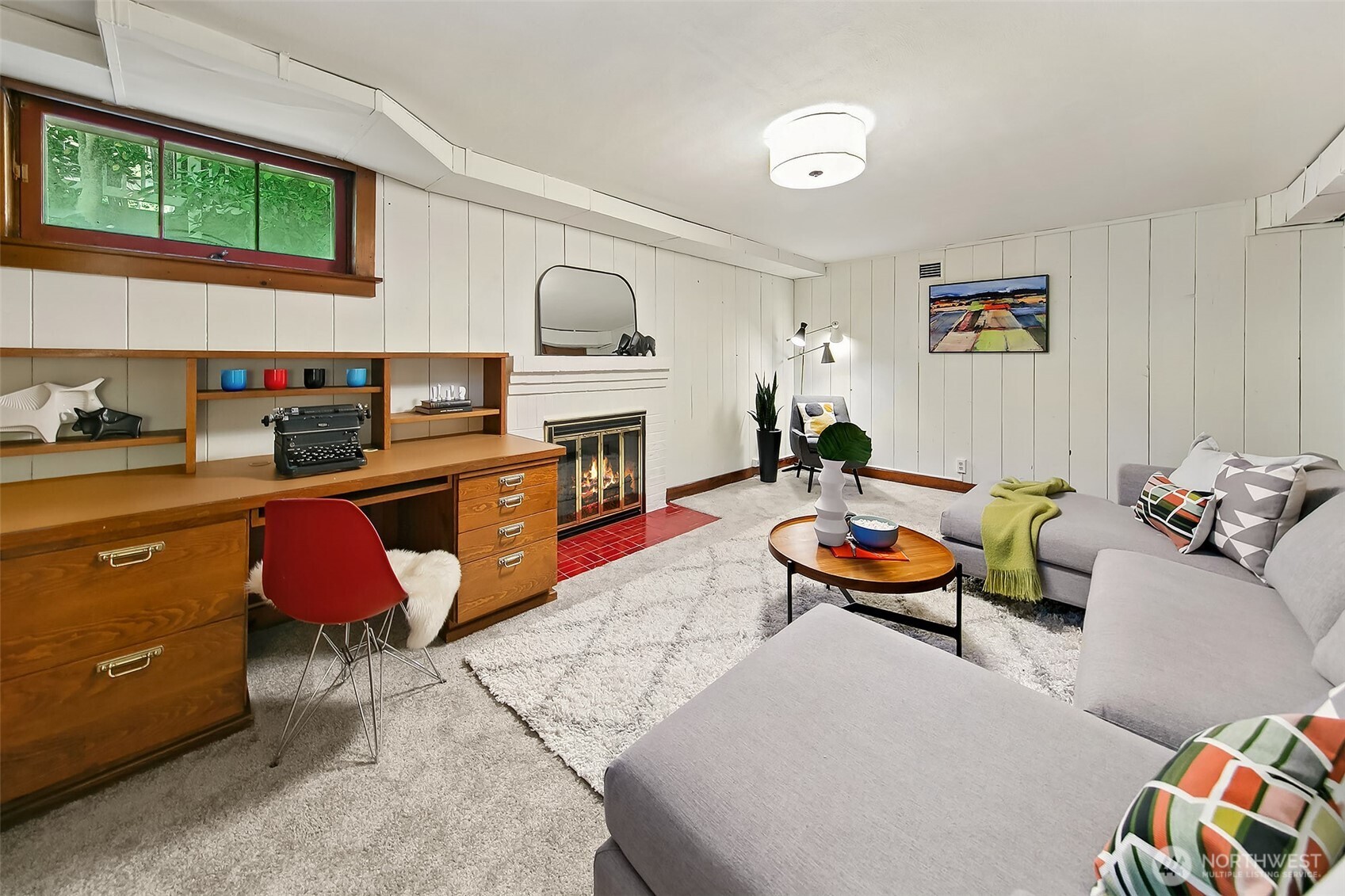 Lower-level multi-purpose room featuring high-set windows, built-in storage, and versatile seating—perfect as a media den, hobby space, or guest retreat.