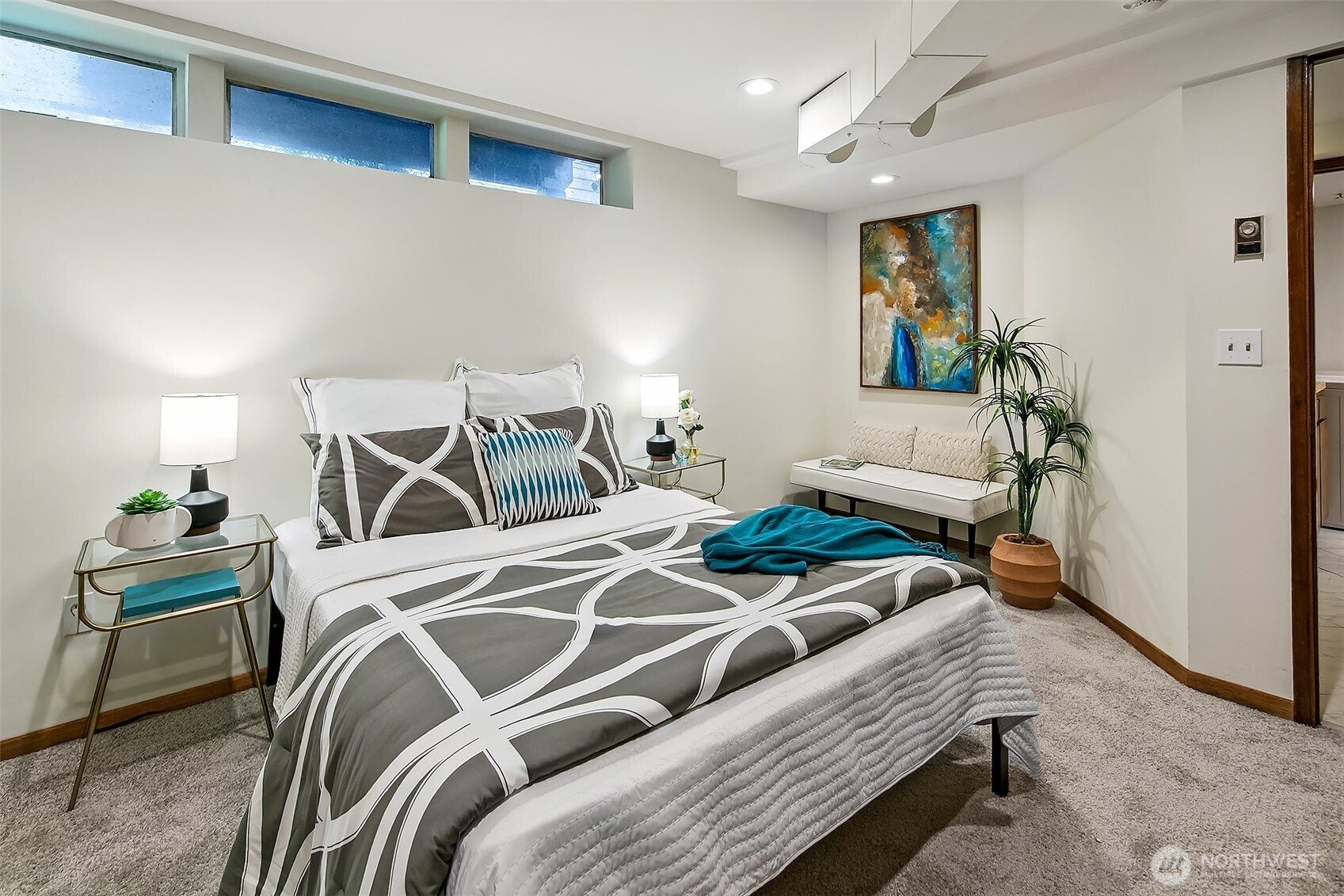 Cozy lower-level bedroom with plush carpeting, high-set windows and built-in storage—may be non-conforming under NWMLS bedroom regulations.