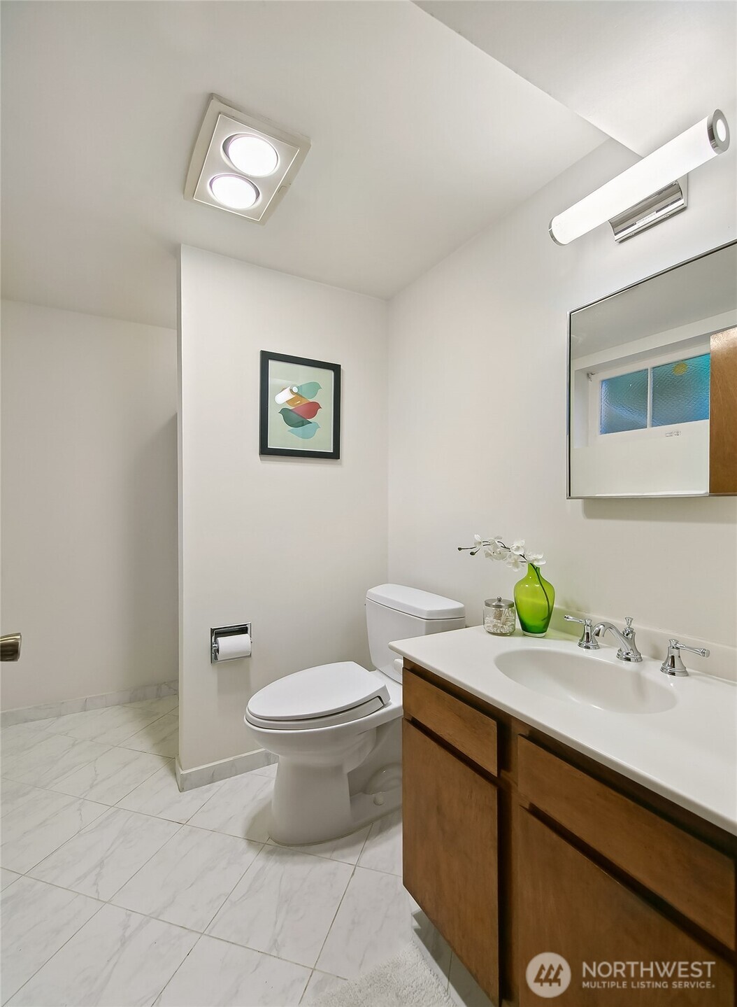 Lower-level laundry room equipped with washer, dryer and abundant overhead cabinetry—designed for seamless household workflow and basement living convenience.