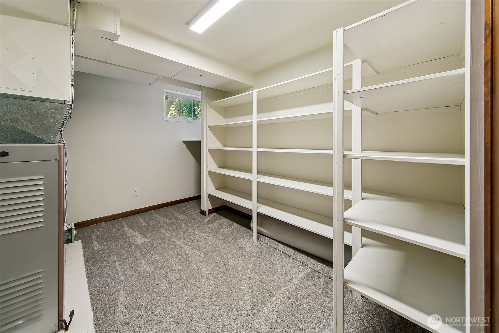 Additional lower-level storage with extensive built-in shelving and high ceilings—perfect for organized seasonal gear, tools or household essentials.