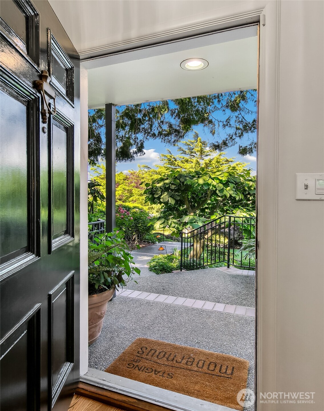 A welcoming entry framed by classic sidelights and transom window, flooding the foyer with light and garden views.