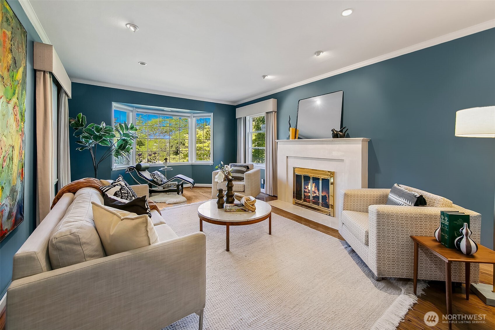 Gracious living room warmed by a classic fireplace and original bay window, where natural light and garden vistas unite in timeless elegance.
