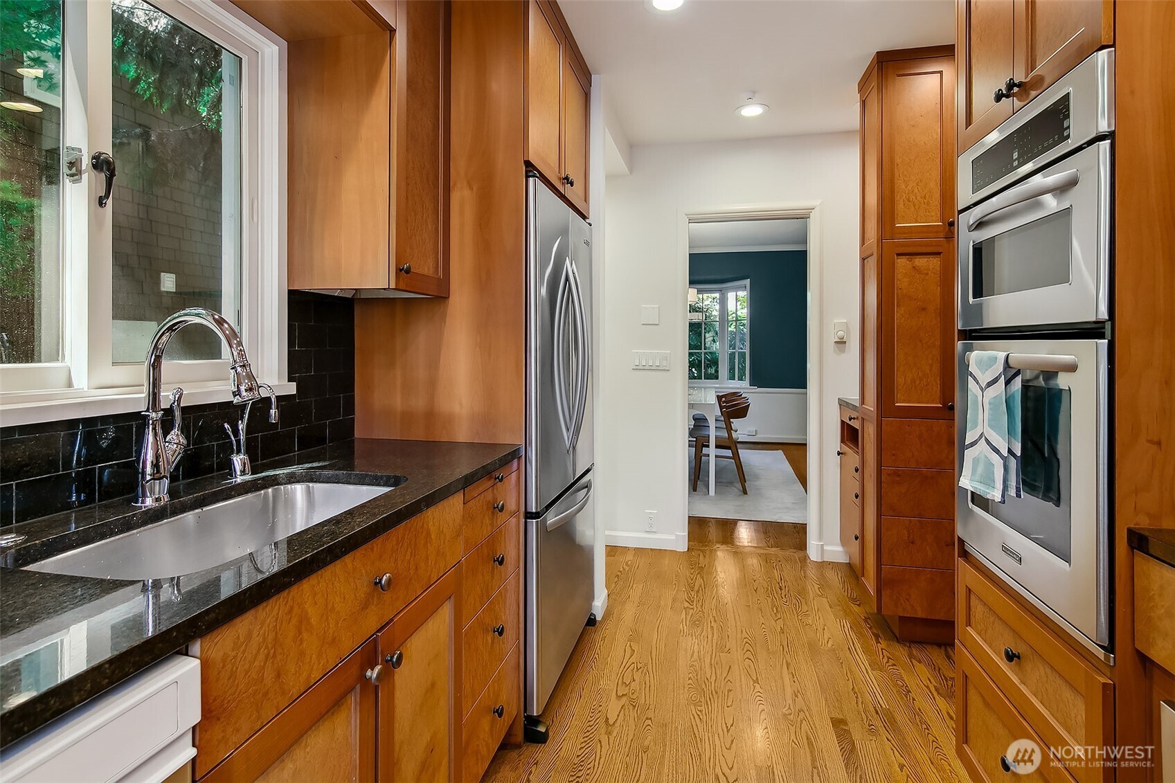 Streamlined galley layout with granite counters and integrated appliances, flowing effortlessly into adjacent service areas for everyday ease.
