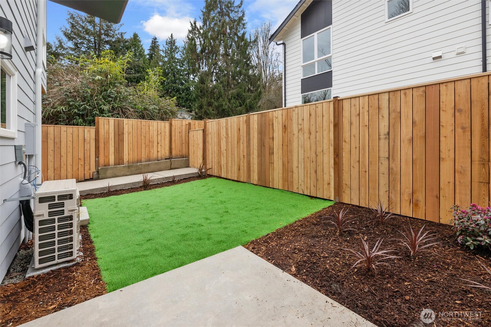 Enjoy a fully enclosed backyard with synthetic lawn and fresh landscaping—ideal for pets or peaceful outdoor lounging.