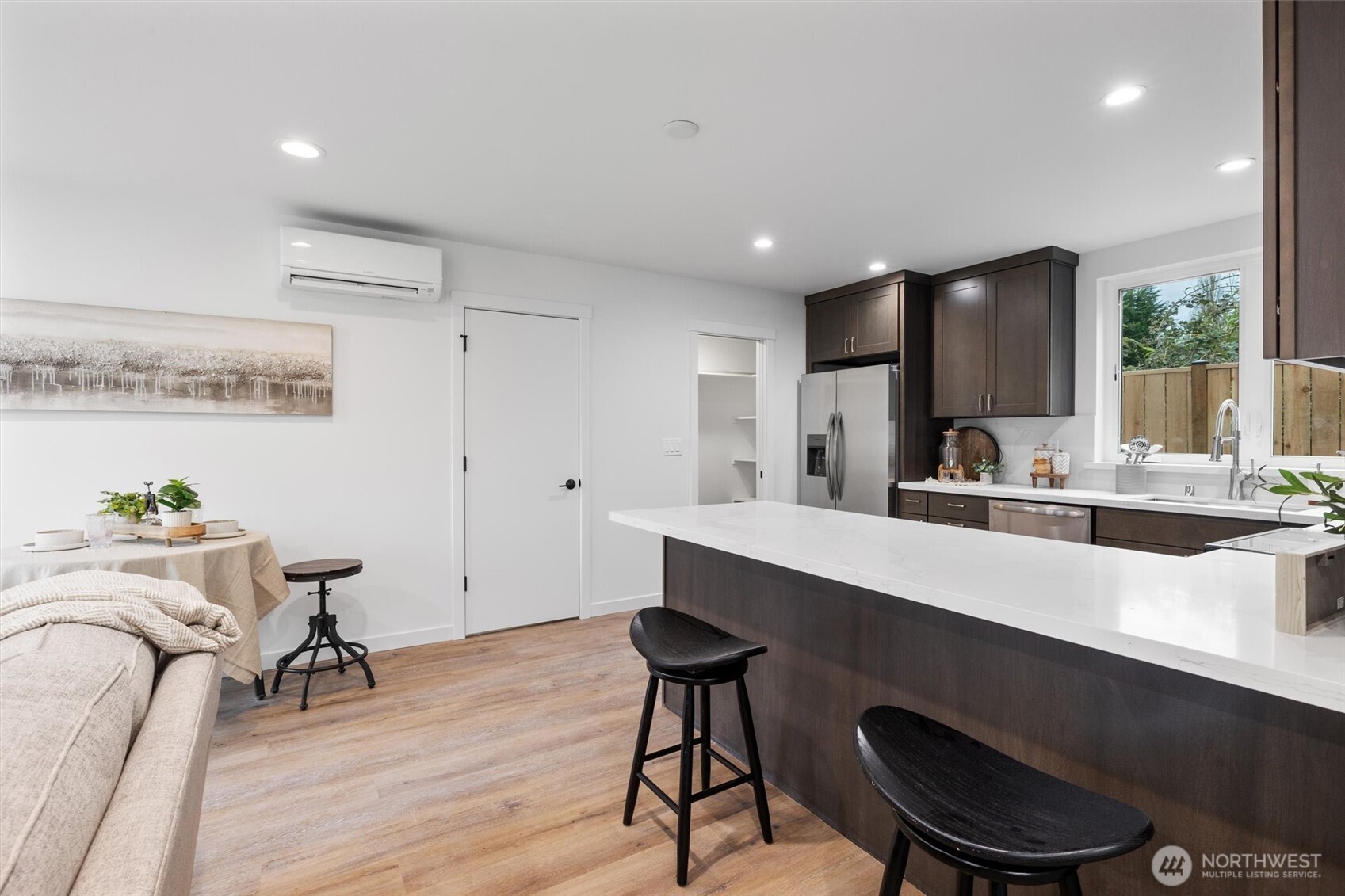 The expansive island with bar seating pairs beautifully with dark wood cabinetry and adjacent walk-in pantry.