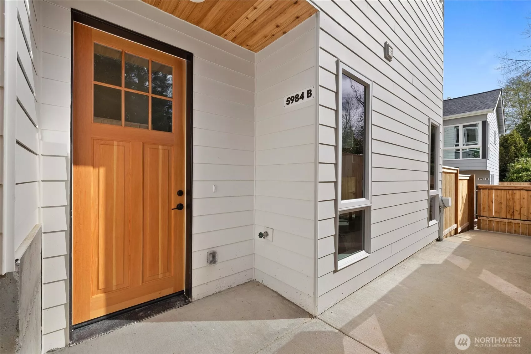 Warm natural wood contrasts beautifully with crisp white siding at the private entry.