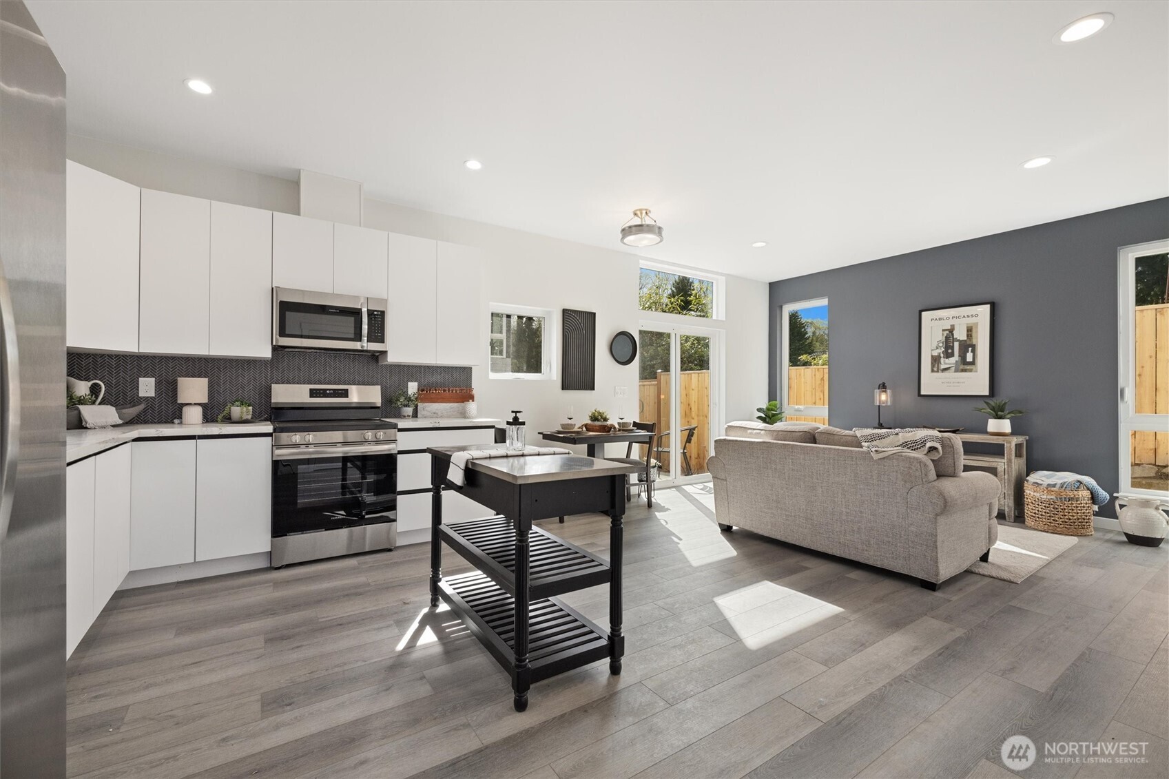 The open-concept kitchen and living area is filled with natural light, complemented by sleek finishes and floor-to-ceiling windows.